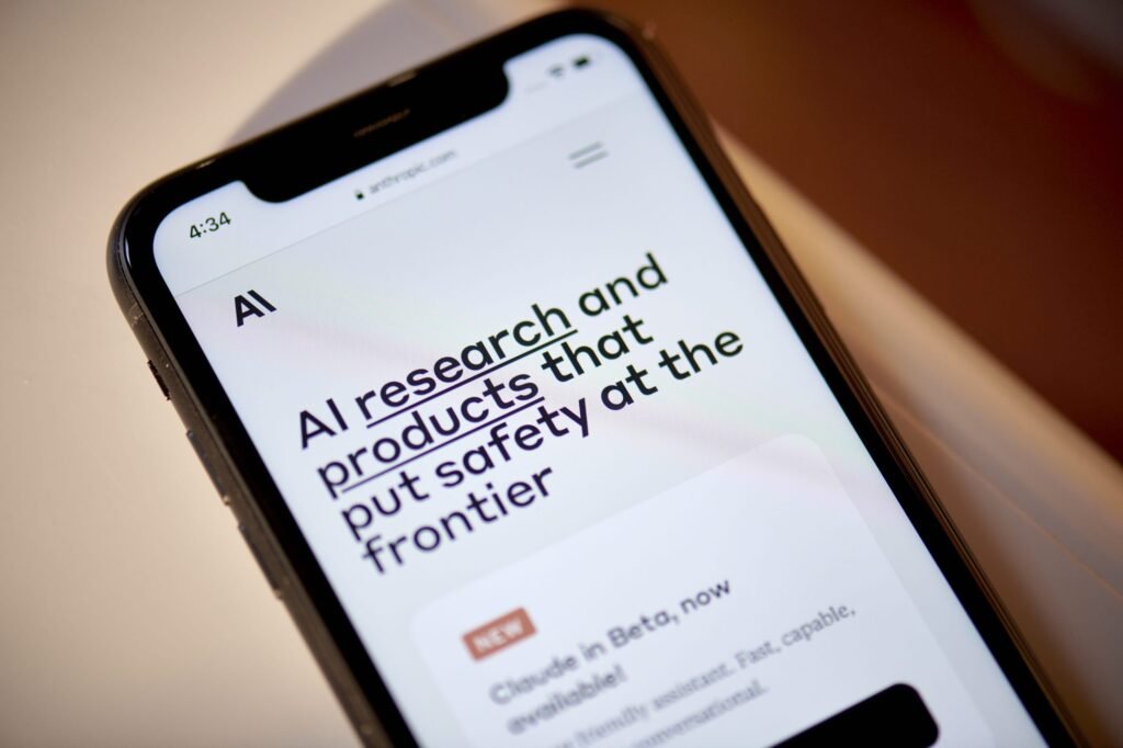 Smartphone mostra site Anthropic.com com a frase "pesquisa e produtos de IA que priorizam a segurança" e a notícia "Claude em Beta".