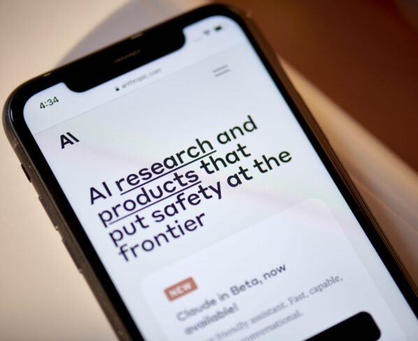 Smartphone mostra site Anthropic.com com a frase "pesquisa e produtos de IA que priorizam a segurança" e a notícia "Claude em Beta".